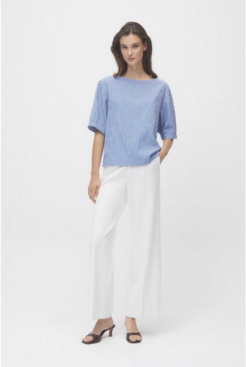 White summer trousers with wide legs and a pressed crease