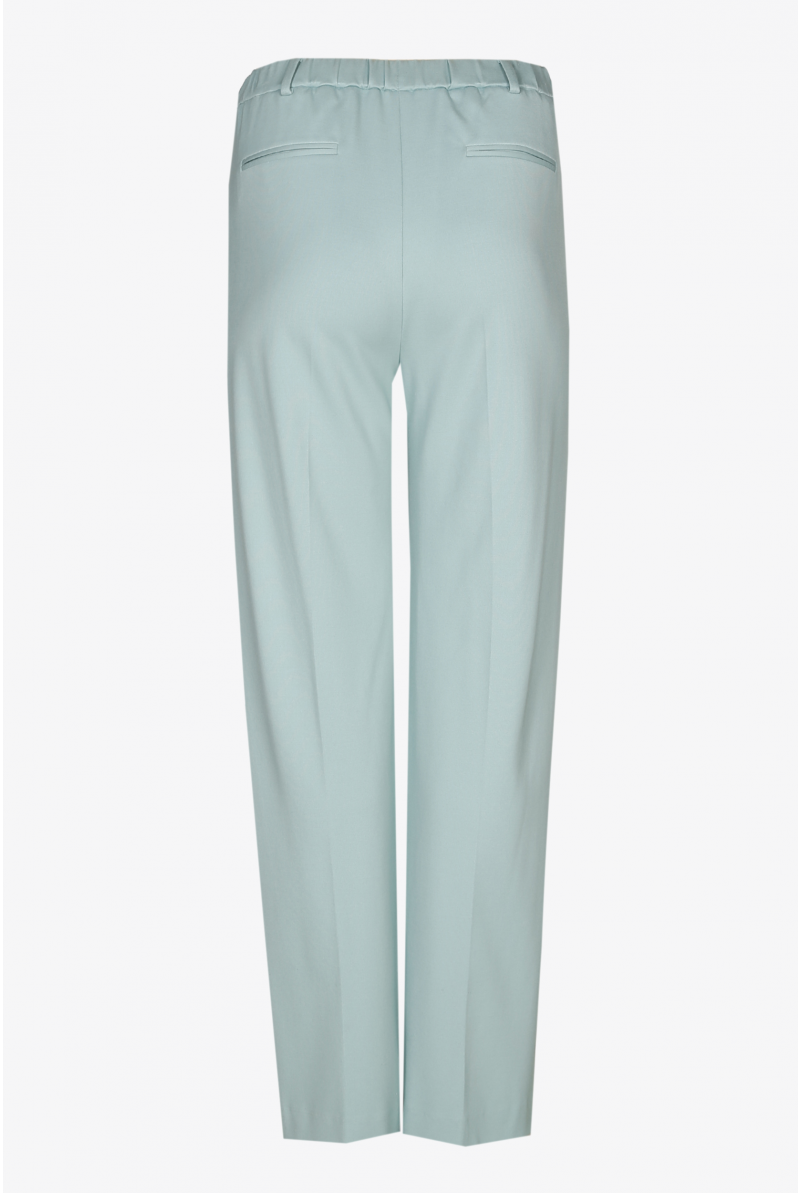 Wide light green trousers with a pressed crease and elastic in the waist