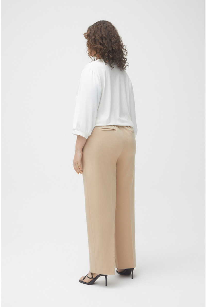 Pantalon large beige avec pli marqué et élastique à la taille